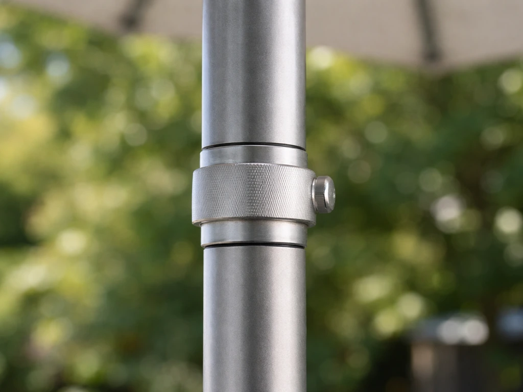 Close-up of an outdoor patio umbrella pole showing telescoping sections and a locking collar detail