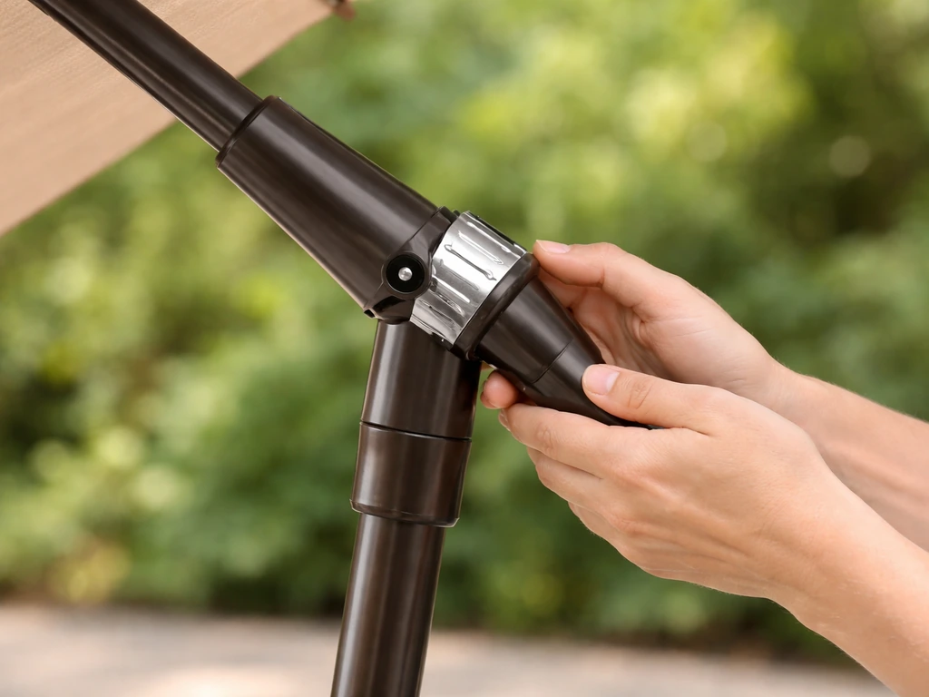 Close-up of hands safely tilting a patio umbrella at the tilt collar while the base is held steady.