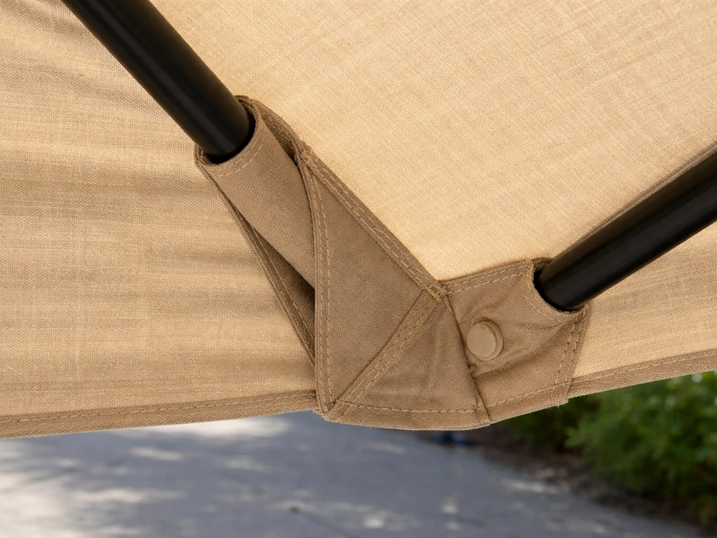 Close-up of a patio umbrella canopy fabric with rib sleeves showing how the ribs slide through